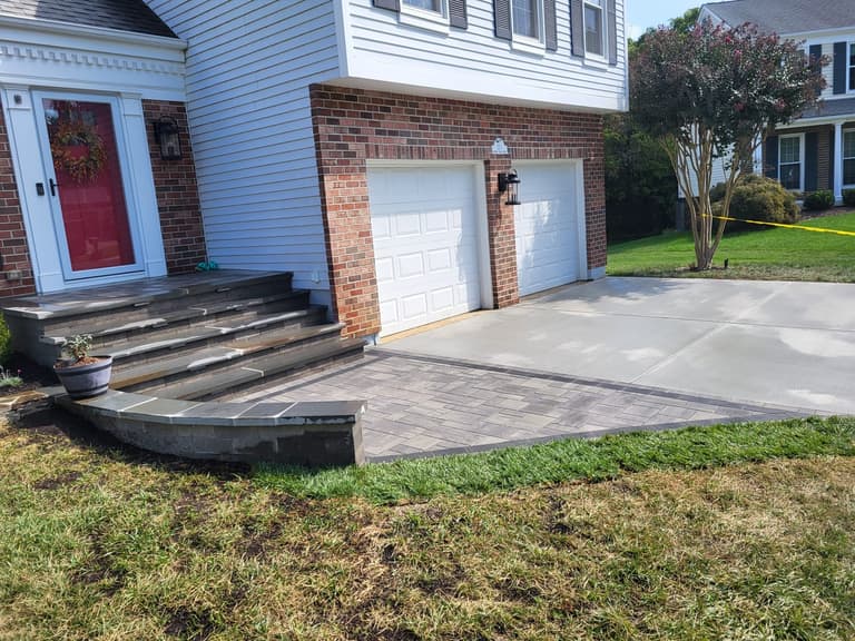 Rebuilt driveway running past a charcoal paver landing and steps at a brick colonial in Annapolis